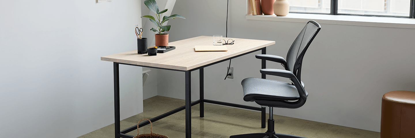Oak top desk with black base and office chair in modern home workspace