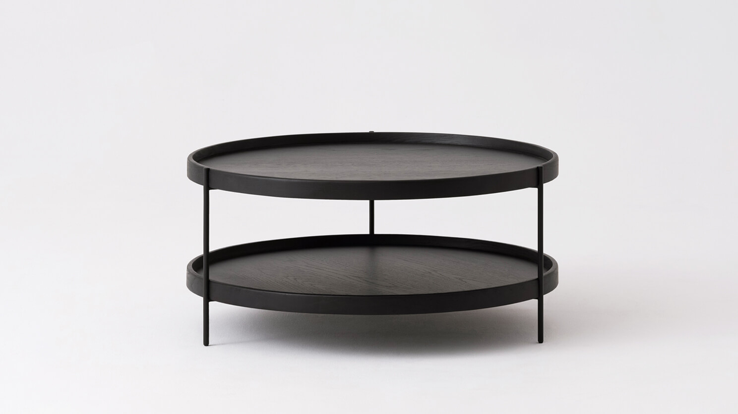 Side view of the small Sage round coffee table in black oak
