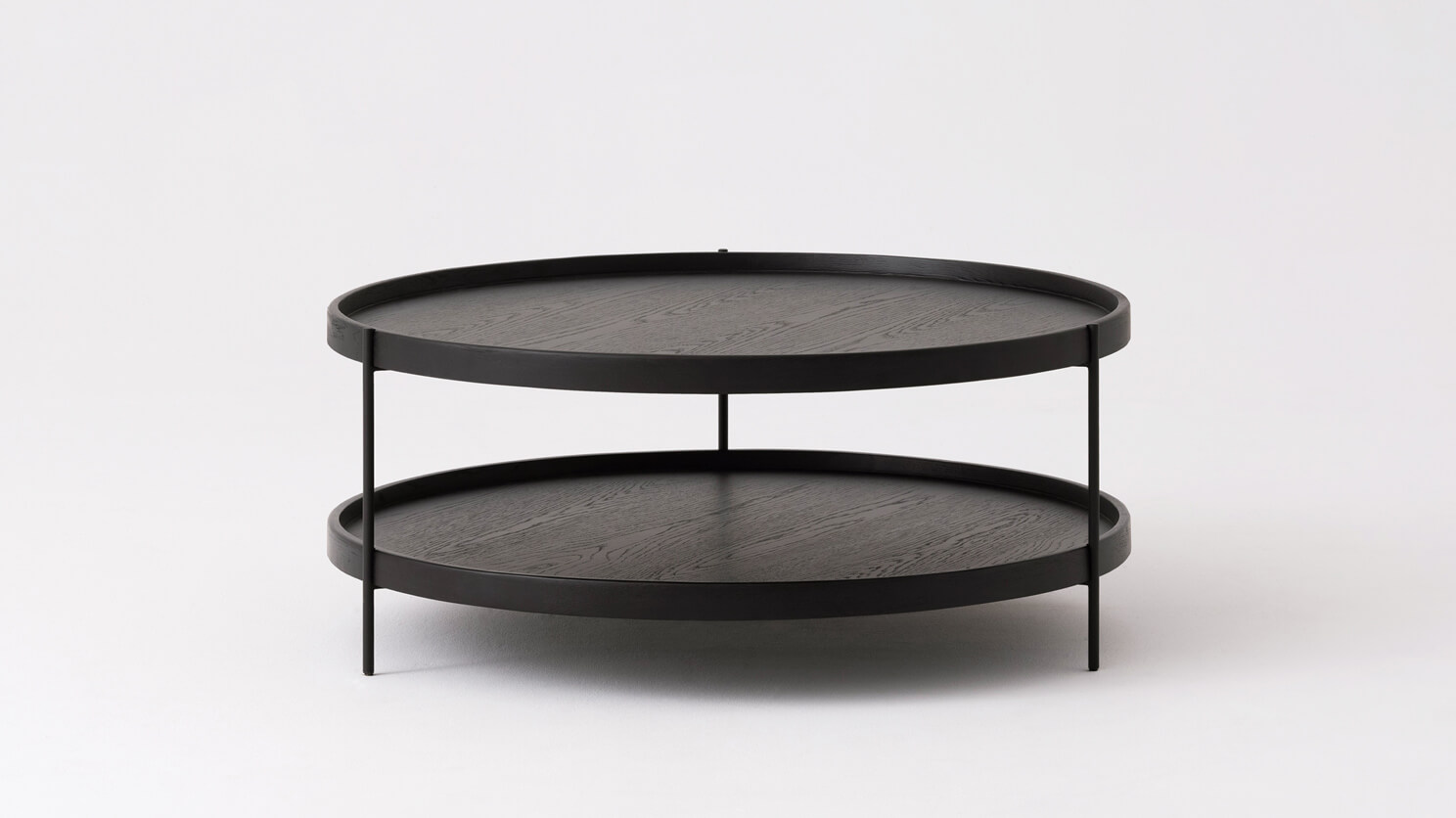 Side view of the large Sage round coffee table in black oak