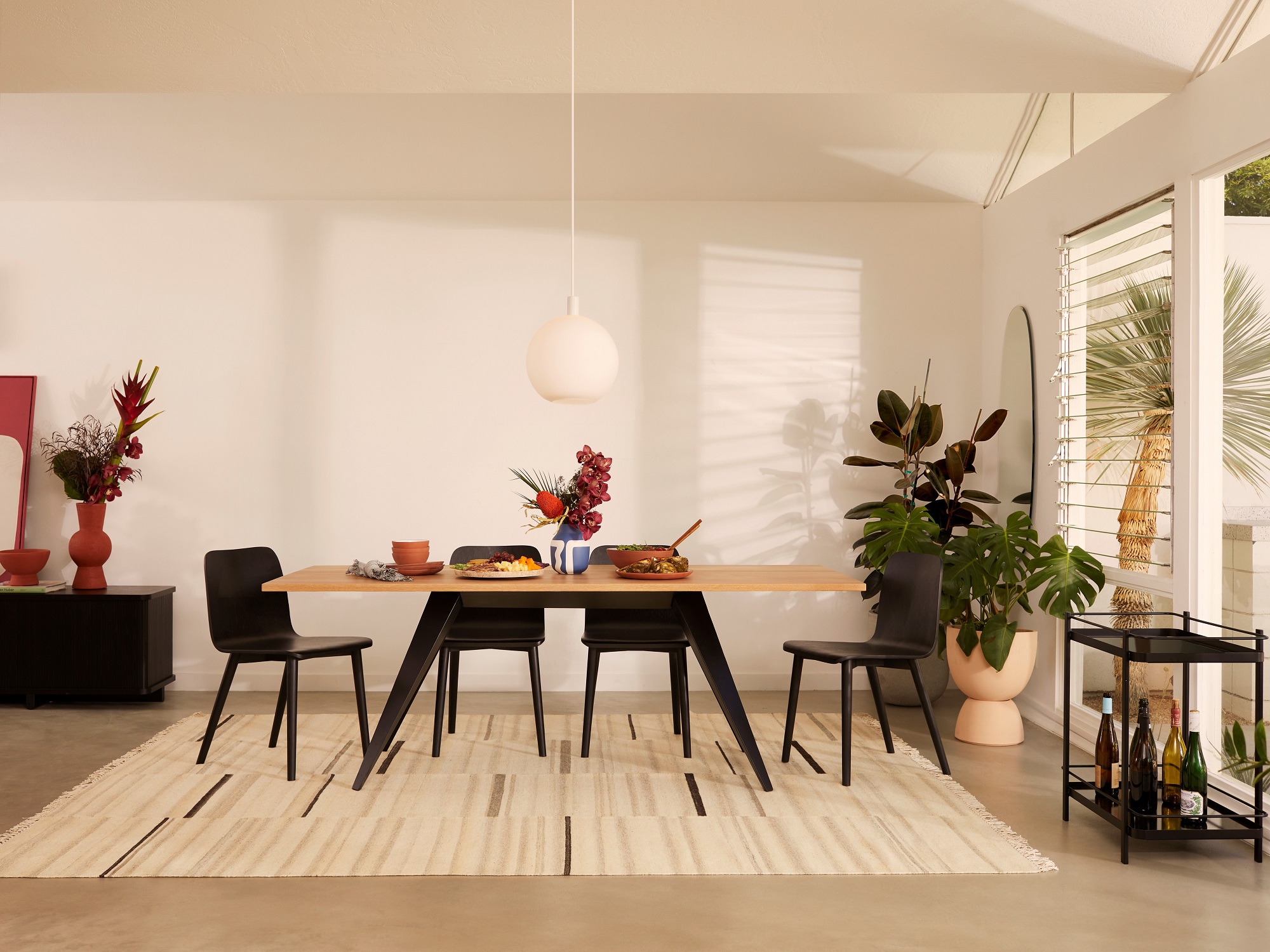 Modern dining table with white striped rug in bright modern home